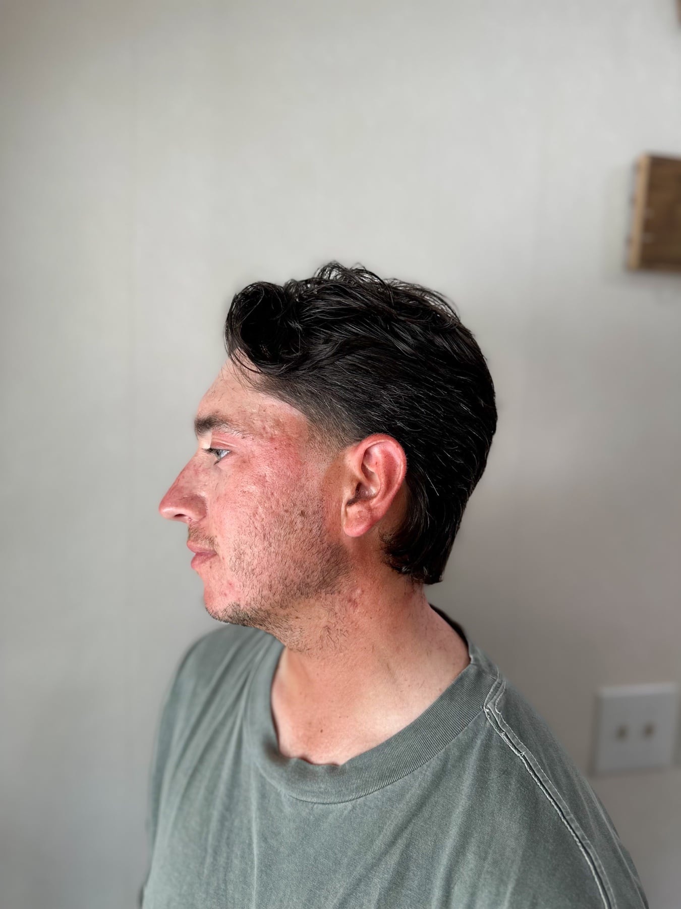 Slicked dark haircut in profile