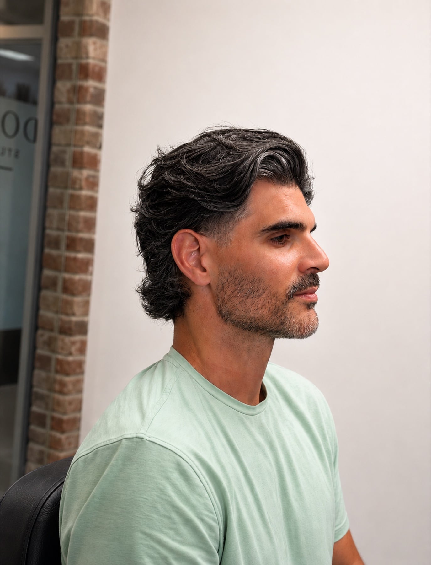 Long salt-and-pepper haircut and beard in profile